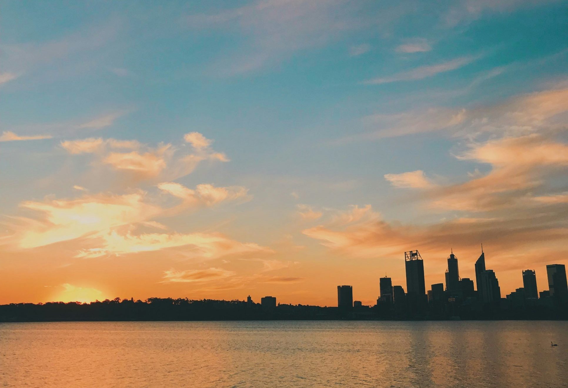 Perth city skyline across the Swan River at sunset